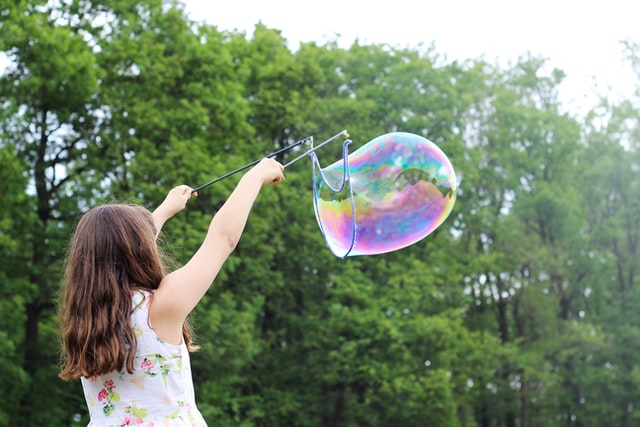 Enfant faisant une bulle géante de savon