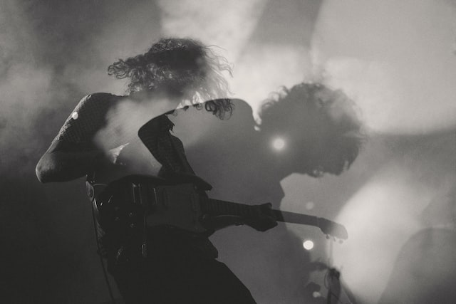 Photo en noir et blanc, guitariste de rock en train de jouer tout en se balançant