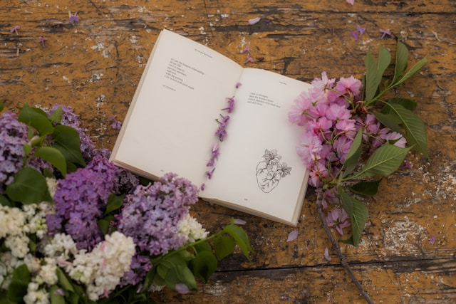 Un livre ouvert avec txte court écrit, posé à côté d'un bouquet. Photo de Jovan Vasiljević