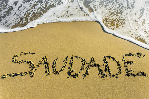 Saudade écrit sur le sable devant la mer