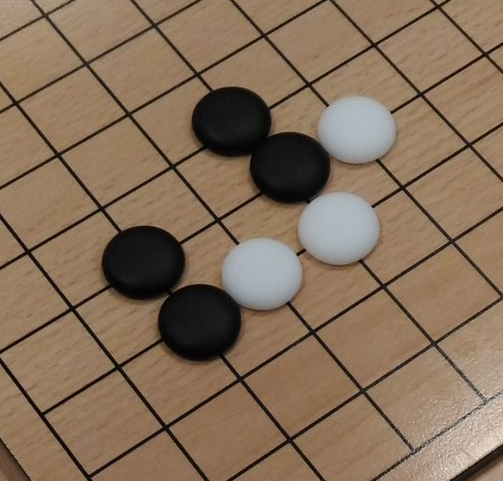 plateau de jeu de go avec pierres blanches et noires