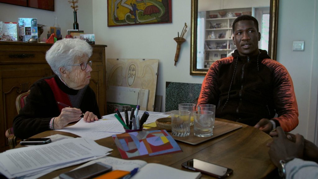 Photo de Marie-José Tubiana et d'un migrant discutant